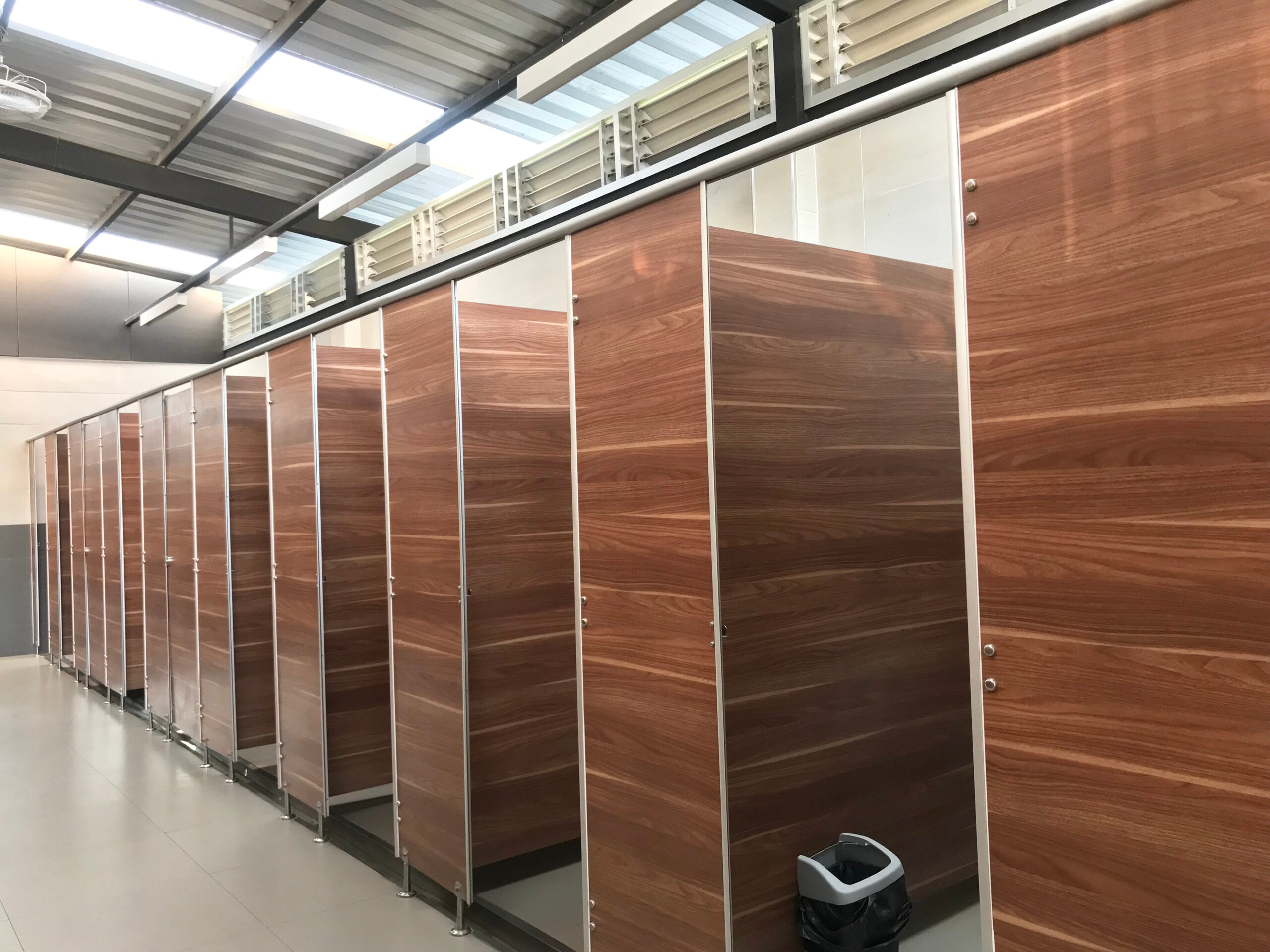 Choosing commercial toilet partitions, like the ones pictured in this image for high-traffic public restroom areas that demand a convenient and aesthetic experience, is no small task.